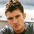 Static pixelated image of a person's head and shoulders with dark hair, light skin tone, and visible facial features against an indistinct background.