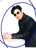 A man in a black suit and sunglasses leans over a white table, with blue circular outlines and colored dots shifting positions