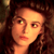 Pixelated static image of a person's face with warm lighting and dark hair against a brown background.
