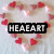A pixelated image with a central black rectangular banner displaying 'HEART' in white block letters, surrounded by scattered red and pink heart shapes on a light gray background.