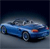 A blue convertible car with a dark interior is positioned on a gradient background transitioning from dark blue to gray, viewed from a side angle.