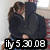 Two figures in dark clothing embrace closely against a light background with partial red and purple tones, overlaid by pixelated text reading 'ily 5 30 08'.