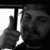 Black-and-white pixelated image of a person holding up two fingers in front of a bright window with vertical bars.