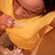 A person in a yellow garment with visible hands and partial face, captured across four showing slight movement