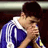 Pixelated static image of a person in sports attire holding a microphone, likely representing a soccer player or athlete at an event.