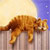 Pixelated orange tabby cat lies on a wooden surface with a gradient background transitioning from yellow to blue.