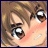 A pixelated close-up of a character's face with brown hair, large eyes, and a blush on the cheeks.