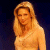 Pixelated image of a person with long blonde hair, closed eyes, and a neutral expression against a dark blue background.