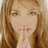 A pixelated image of a person with light brown hair and blue eyes, hands clasped near the mouth, against a light blue background with text elements.