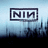 Pixelated image with 'NIN' logo, blue text 'Nine', 'Inch', and 'Nails' on black background, blue and white color scheme.