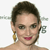 Pixelated close-up of a person with short dark hair, wearing a gold earring and red lipstick, against a white background.
