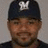 A pixelated image of a person wearing a dark cap with white logo, set against blue background with yellow text.