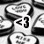 <3 icon with pixelated black-and-white background, white speech bubble containing <3 symbol in dark gray.