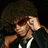 Pixelated image of a person with curly hair adjusting sunglasses, green text reading "Isn't he gorgeous?" on black background.