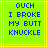 A static pixel art image with bright green background and yellow lines, displaying blue text reading "OUCH I BROKE MY BUTT KNUCKLE" in blocky font