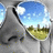 Pixelated image of a gray animal head with black markings, blue sky background, and green-yellow object below.