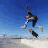 A static image shows a skateboarder mid-air performing a trick against a blue sky, with text elements arranged around the edges.