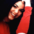 Pixelated close-up of a person in a red garment with a dark background, showing a smiling face and raised arm.