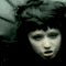 Animated sequence of a person with long dark hair and blue eyeshadow in various facial expressions against a muted background.