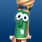 Pixelated green vegetable character with large eyes and white mouth, held by brown hands against blue background.