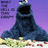 A dark blue furry creature with a large open mouth sits on a grassy patch against a purple background, with partial text visible on the left side.
