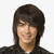 Two side-by-side pixelated images of a person with dark brown hair and black clothing against white background.