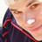 Pixelated close-up of a person's face with dark hair and red accents on clothing, set against a light background.