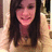 A pixelated static image of a person with long dark hair wearing a brown top against a light background.