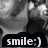 Black-and-white image of a person with short hair smiling, overlaid with text reading "smile:)" on a dark banner.