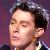 Static 50x50 pixel icon showing a close-up of a person's face with dark hair and light skin against a purple background, rendered in low-resolution pixel art style.