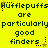 Yellow background with dark green text repeating 'Hufflepuffs are particularly good finders' in a pattern, featuring small star and dot decorations