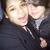 Two people in dark jackets pose closely together, one with a hand on the other's shoulder, in a pixelated image with visible motion blur.