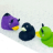 Three pixelated cartoon birds in profile view: purple with yellow beak, black with white eye patch, green with yellow beak on light gray background.