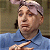 Static 50x50 pixel icon showing a person in blue shirt with light hair, partially cropped face and hand gesture against muted background.