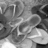 Grayscale pixelated image of a figure in motion with blurred limbs and indistinct background elements.