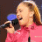 A 2x2 contact sheet of four distinct frames from an animated American Idol icon, showing a woman singing into a microphone, smiling against red background, and the blue oval American Idol logo on black.