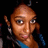 Pixelated close-up of a person with light brown skin tone, dark eyes, and short hair wearing blue clothing against black background.