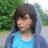A static image shows a person with brown hair in a blue hoodie and shirt against a green background, with white pixelated text on black