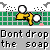 Pixel art buddy icon featuring a yellow running stick figure with white circular eyes against a green grid background and text reading "Dont drop the soap" in pixelated font.