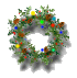 Circular green wreath with brown pine cones, multicolored round ornaments (red, blue, yellow, green), and a single yellow flower at the top center.
