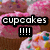 Pixelated image with pink and brown background showing text 'cupcakes' in white letters on black bar above four exclamation marks.