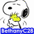Snoopy cartoon character with yellow beak, black eyes and ears, white body, holding a small object in front of its face against a white background.