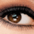 A close-up of a human eye with brown iris, black eyelashes, and visible skin texture in pixelated style.