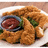 A plate of fried food with a side of sauce and greens, overlaid with blue pixelated text reading 'afied' on the right.