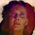 Pixelated close-up of a person with curly hair, showing partial facial features and warm-toned skin under soft lighting.