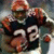 Pixelated image of a football player in dark uniform with white number 28, holding an orange ball, against blurred background.