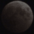 A pixelated circular shape with gradient shading from dark gray to light gray against a black background, resembling a moon or celestial body.