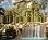 Static pixelated image of a building with multiple windows and architectural details under a light sky.