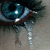 A close-up of a blue eye with tears, accompanied by text reading "I want him <3" in a pixelated font.