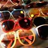 A dense arrangement of multiple sunglasses icons with varied frame colors and lens tints, some featuring reflective highlights.